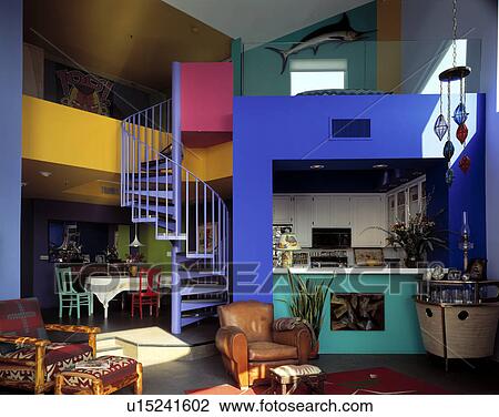 Spiral staircase in large openplan kitchen dining and living room painted in bright primary colours View Large Photo Image Stock Image - Spiral staircase in large openplan kitchen dining and living room painted in bright primary colours. Fotosearch