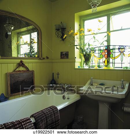 Stained glass panel on window above basin in lime green bathroom with rolltop bath and panelling to dado height View Large Photo Image Stock Image - Stained glass panel on window above basin in lime green bathroom with rolltop bath and panelling to dado height. Fotosearch