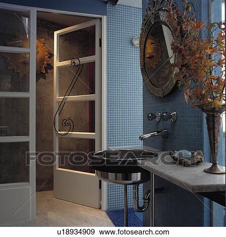 Stainless steel basin in marble shelf in pastel blue mosaic tiled bathroom with open glazed double doors View Large Photo Image Stock Photo - Stainless steel basin in marble shelf in pastel blue mosaic tiled bathroom with open glazed double doors. Fotosearch