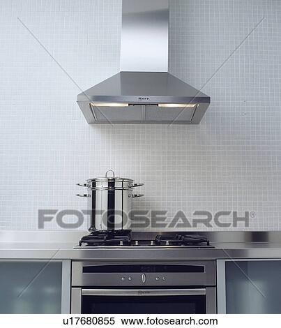 Stock Photography - Stainless steel extractor above tall steel pan on hob&#13; &#10; &#13; &#10; &#13; &#10; &#13; &#10; &#13; &#10; &#13; &#10;. Fotosearch