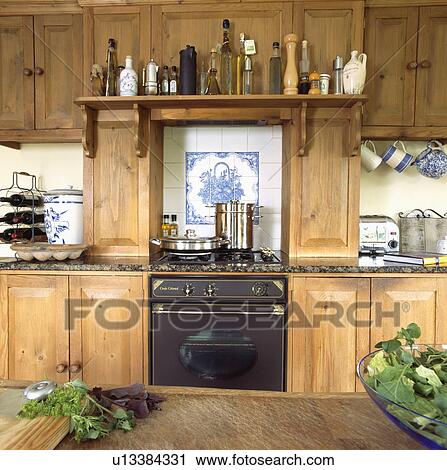Stainless steel pans on oven below shelf in reclaimed wood kitchen View Large Photo Image Stock Image - Stainless steel pans on oven below shelf in reclaimed wood kitchen. Fotosearch