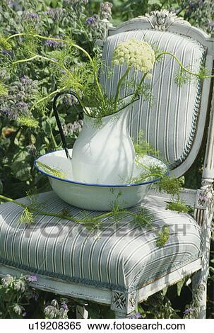Stock Photography - Still-Life of flowers in jug on chair. Fotosearch