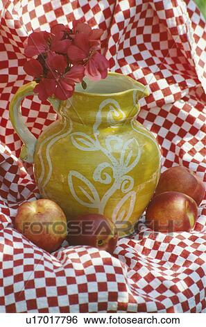 Stock Photograph - Still-Life of yellow jug and red+white checked fabric. Fotosearch
