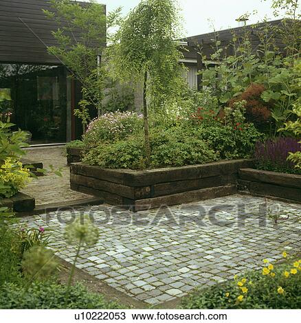 Stone paving in green town garden in summer View Large Photo Image Stock Image - Stone paving in green town garden in summer. Fotosearch