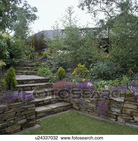Stock Image - Stone steps and in country garden in summer. Fotosearch
