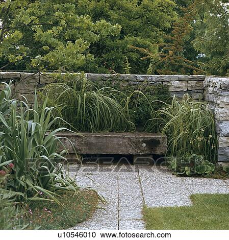 Stock Image - Stone wall in country garden. Fotosearch