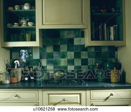 Storage jars and built-in hob in kitchen worktop below green wall tiles View Large Photo Image Stock Photo - Storage jars and built-in hob in kitchen worktop below green wall tiles. Fotosearch
