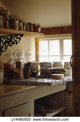 Storage jars on shelf above glass jars on marble slab in cottage larder View Large Photo Image Stock Image - Storage jars on shelf above glass jars on marble slab in cottage larder. Fotosearch