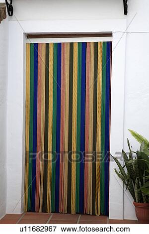 Stock Photo - Striped blind on door of traditional Spanish house. Fotosearch