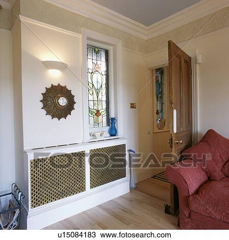 Sunburst clock and stained glass window above radiator in living room View Large Photo Image Stock Image - Sunburst clock and stained glass window above radiator in living room . Fotosearch