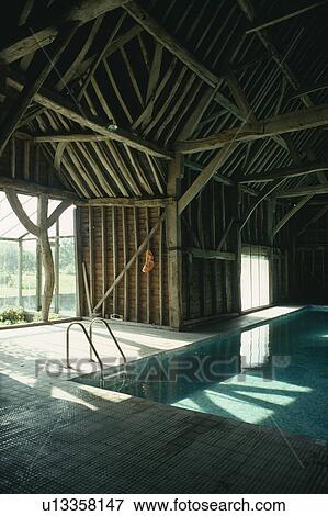 Sunlight streaming through the windows of indoor swimming pool in traditional barn conversion View Large Photo Image Stock Photo - Sunlight streaming through the windows of indoor swimming pool in traditional barn conversion. Fotosearch