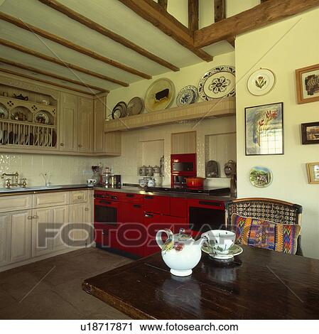 Teapot and cup on wooden table in country kitchen with red Aga View Large Photo Image Stock Image - Teapot and cup on wooden table in country kitchen with red Aga. Fotosearch