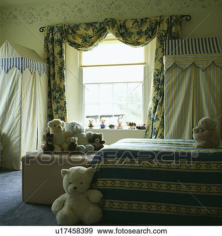Tented fabric storage wardrobes in child's bedroom with blue+yellow drapes at the window View Large Photo Image Stock Photo - Tented fabric storage wardrobes in child's bedroom with blue+yellow drapes at the window. Fotosearch