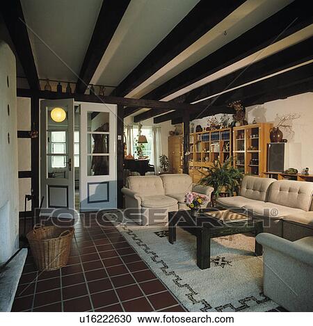 Stock Image - Tiled floor in beamed country living room. Fotosearch