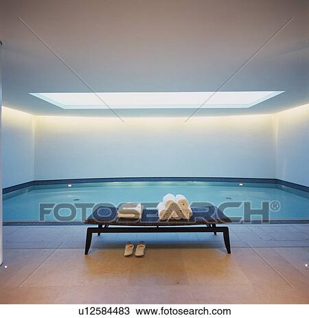 Towels on bench in modern indoor swimming pool View Large Photo Image Stock Image - Towels on bench in modern indoor swimming pool. Fotosearch
