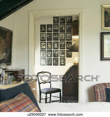 Stock Photo - Townhouse bedroom with view through doorway of collection of black and white photographs on the wall of small dressingroom . Fotosearch