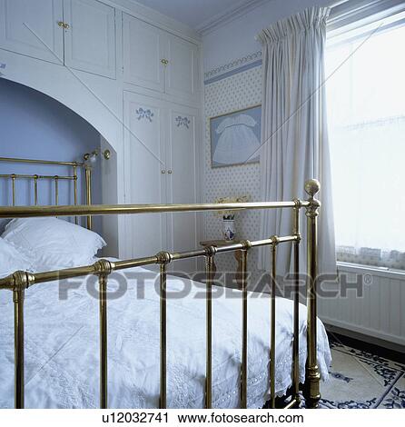Traditional bedroom with antique brass bed in alcove with built-in storage cupboards View Large Photo Image Stock Image - Traditional bedroom with antique brass bed in alcove with built-in storage cupboards. Fotosearch