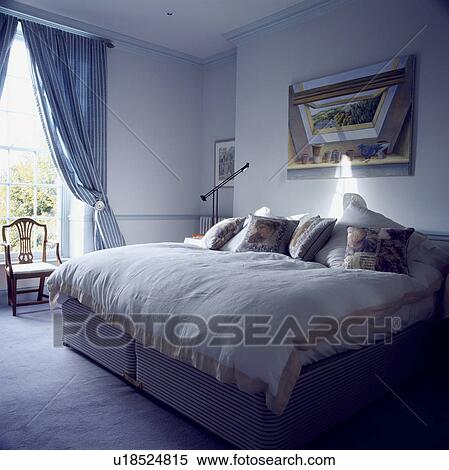 Stock Photography - Traditional blue and white bedroom with frilly blue curtains. Fotosearch