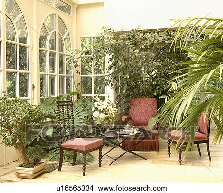Traditional conservatory living room with comfortable furniture and green plants View Large Photo Image Picture - Traditional conservatory living room with comfortable furniture and green plants. Fotosearch