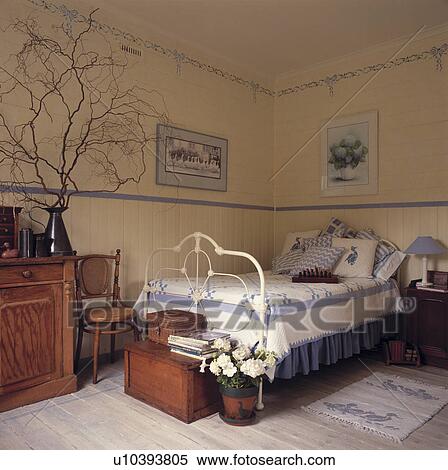 Traditional country bedroom with stencils, blue painted dado rail and iron bedstead. View Large Photo Image Stock Photography - Traditional country bedroom with stencils, blue painted dado rail and iron bedstead.. Fotosearch