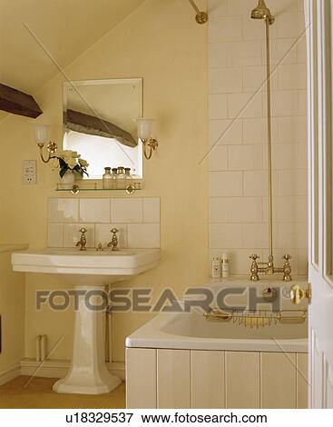 Stock Photo - Traditional cream and white bathroom with black stained beams under the eaves of an attic conversion. Fotosearch