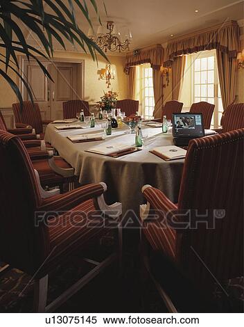Traditional dining room in restaurant with place settings on long table View Large Photo Image Stock Photography - Traditional dining room in restaurant with place settings on long table. Fotosearch