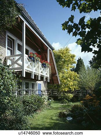 Traditional German small country house with red geraniums on balcony View Large Photo Image Stock Image - Traditional German small country house with red geraniums on balcony . Fotosearch