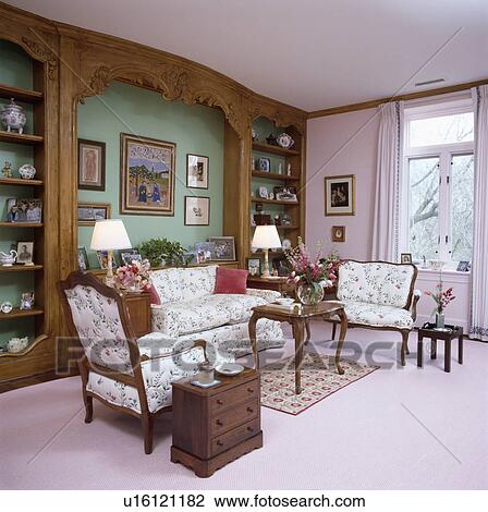 Stock Image - Traditional pink living room with built-in bookshelves and pink carpet. Fotosearch