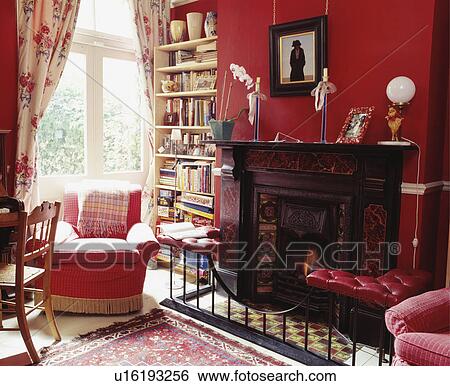 Traditional red living room with club-seat in front of fireplace View Large Photo Image Stock Photograph - Traditional red living room with club-seat in front of fireplace. Fotosearch