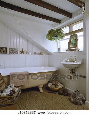 Traditional style bathroom with a roll top bath, beams on ceiling and natural fibre floor covering View Large Photo Image Stock Photo - Traditional style bathroom with a roll top bath, beams on ceiling and natural fibre floor covering. Fotosearch