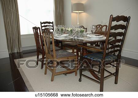 Traditional table and chairs in modern dining room with cream rug View Large Photo Image Stock Photo - Traditional table and chairs in modern dining room with cream rug. Fotosearch