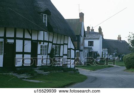 Traditional thatched and timbered black+ white cottage in country village View Large Photo Image Stock Photo - Traditional thatched and timbered black+ white cottage in country village. Fotosearch