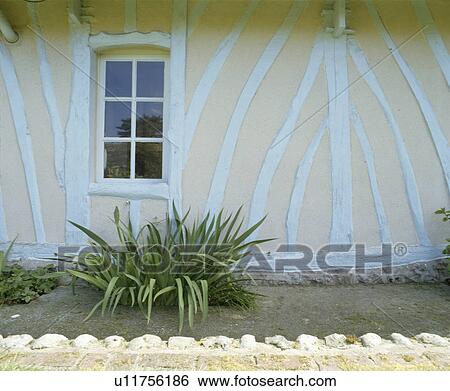 Stock Photograph - Traditional white and cream timbered country cottage in France. Fotosearch