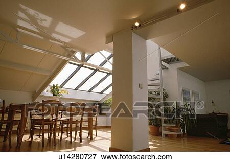 Stock Photo - Traditional wooden table and chairs in modern white openplan loft conversion. Fotosearch
