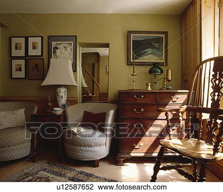 Tub armchairs and antique chest-of-drawers in traditional cottage living room View Large Photo Image Stock Image - Tub armchairs and antique chest-of-drawers in traditional cottage living room. Fotosearch