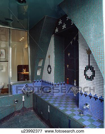 Stock Photo - Turquoise blue and white patterned mosaic tiled wall above sunken bath in Moorish-style bathroom. Fotosearch