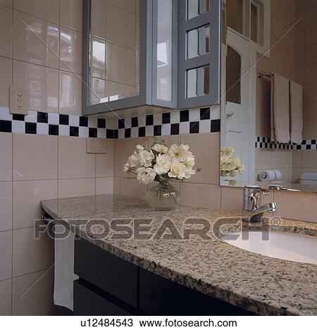 Underset white basin in granite-topped vanity unity in modern tiled bathroom with black+white chequerboard tiled border View Large Photo Image Stock Image - Underset white basin in granite-topped vanity unity in modern tiled bathroom with black+white chequerboard tiled border. Fotosearch