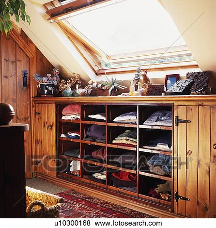 Velux Window Above Clothes On Open Shelves In Attic Bedroom Stock Photo