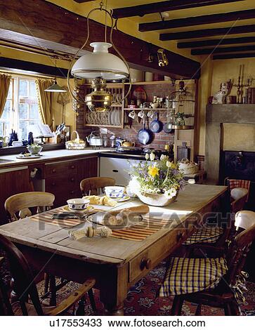 Victorian brass and glass lamp above pine table in cottage kitchen View Large Photo Image Stock Image - Victorian brass and glass lamp above pine table in cottage kitchen . Fotosearch