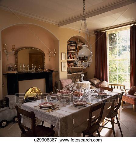 Victorian Glass And Brass Light Above Table With Place Settings On White Cloth In Dining Room Fireplace Alcove Victorian Glass And Brass Light Above Table With Place Settings On White Cloth In Dining Room Fireplace Alcove