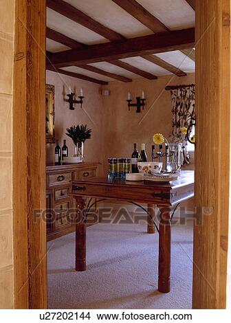 View through doorway to Indian-style table in beamed cottage dining room View Large Photo Image Picture - View through doorway to Indian-style table in beamed cottage dining room. Fotosearch