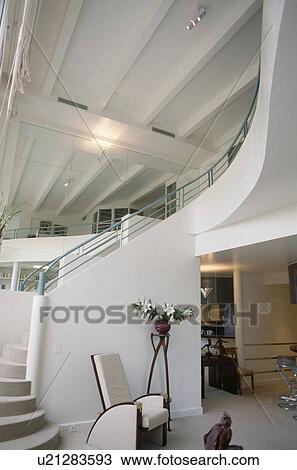 Walled staircase with grey metal handrail in white double storey hall in white loft conversion View Large Photo Image Stock Image - Walled staircase with grey metal handrail in white double storey hall in white loft conversion. Fotosearch