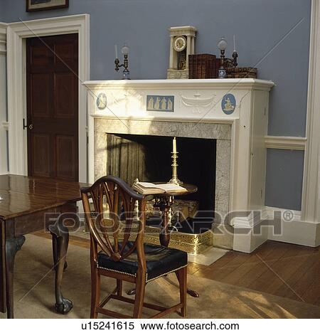 Stock Photography - Wedgewood fireplace and antique furniture in blue dining room. Fotosearch