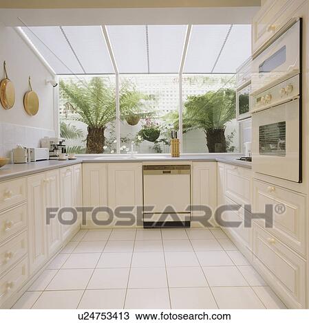 White Ceramic Floor Tiles In Modern White Kitchen With Dishwasher