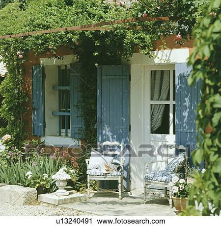 White chairs in front of Provencal cottage with blue shutters View Large Photo Image Stock Image - White chairs in front of Provencal cottage with blue shutters. Fotosearch