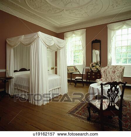 White Drapes And Linen On Fourposter Bed In Country Bedroom