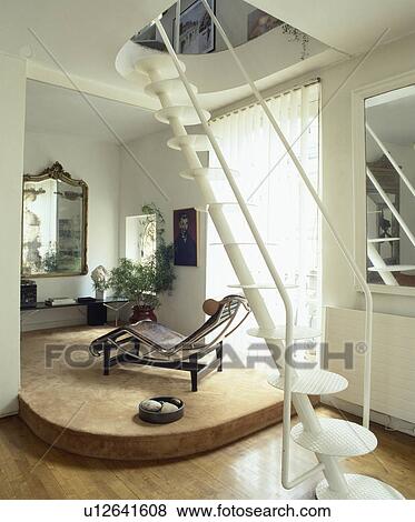 White metal staircase with flat circular treads in eighties modern hall with Le Corbusier chaiselongue View Large Photo Image Stock Photo - White metal staircase with flat circular treads in eighties modern hall with Le Corbusier chaiselongue. Fotosearch