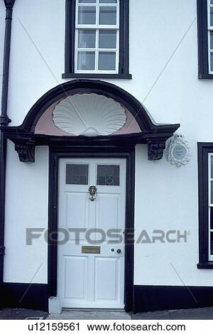 White Plaster Seashell Below Pediment Above White Georgian Front Door In Black White House Stock Image