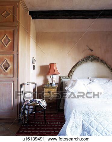 White quilt and pillows on single bed with padded headboard in Spanish bedroom with rough plaster walls View Large Photo Image Stock Image - White quilt and pillows on single bed with padded headboard in Spanish bedroom with rough plaster walls. Fotosearch