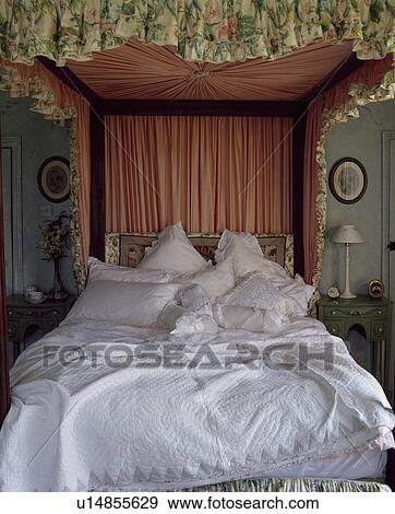 White quilt and white pillows and cushions piled on half-tester bed with peach and floral curtains View Large Photo Image Stock Photo - White quilt and white pillows and cushions piled on half-tester bed with peach and floral curtains. Fotosearch